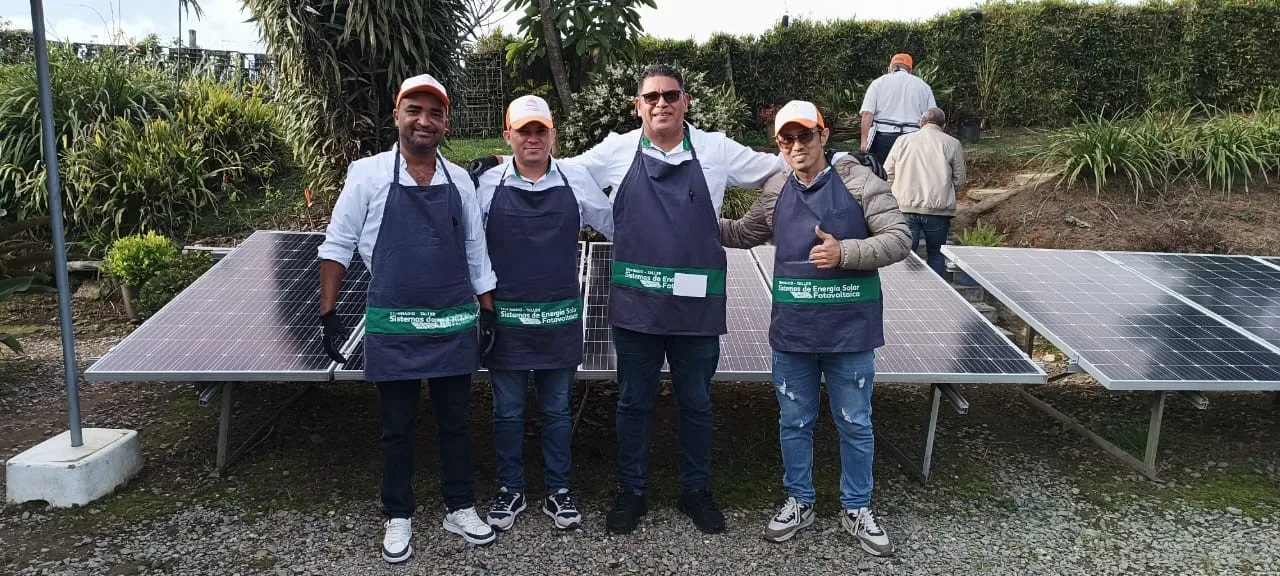 Directivos de la cooperativa Coomustier posando delante de paneles solares